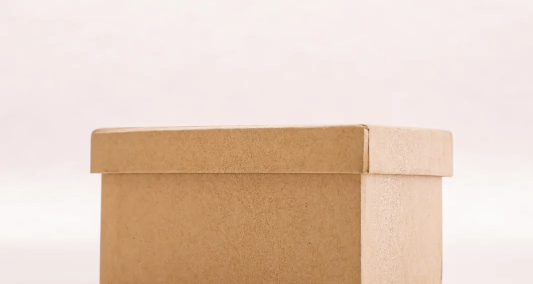 Caixa de papel kraft fechada, usada para transporte de doces