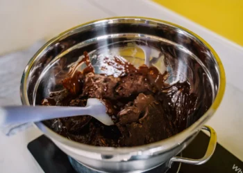 Chocolate derretido sendo preparado em tigela, textura mole e brilhante (imagem ilustrativa)