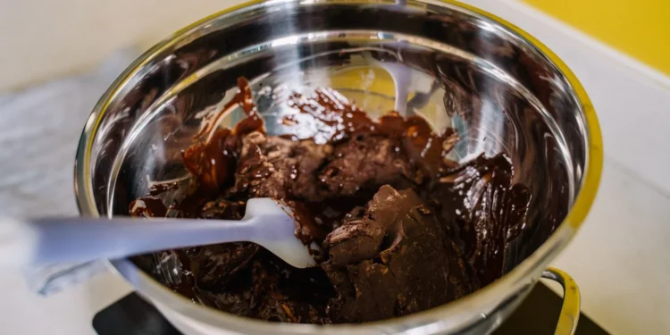 Chocolate derretido sendo preparado em tigela, textura mole e brilhante (imagem ilustrativa)