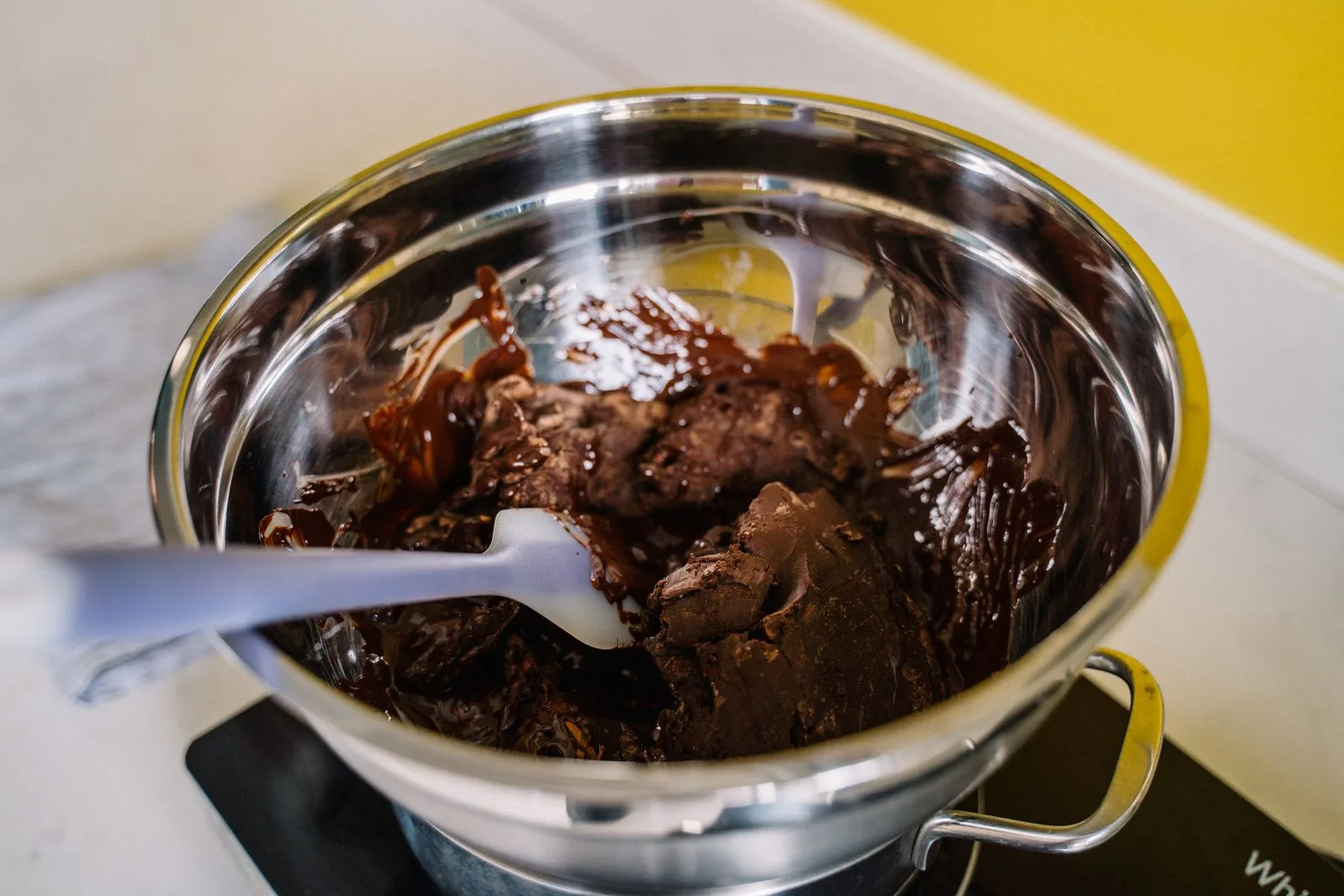 Chocolate derretido sendo preparado em tigela, textura mole e brilhante (imagem ilustrativa)
