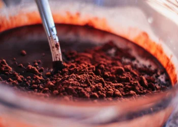 Close-up de chocolate em pó sendo misturado, mostrando a textura granulada