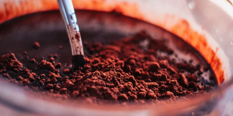 Close-up de chocolate em pó sendo misturado, mostrando a textura granulada