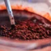 Close-up de chocolate em pó sendo misturado, mostrando a textura granulada