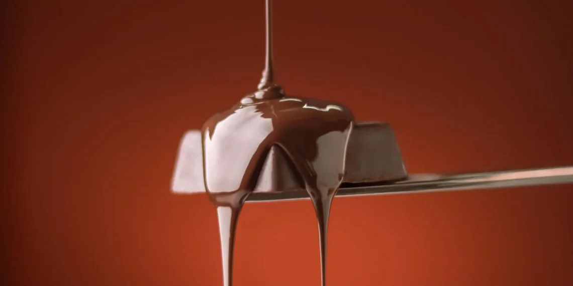 Chocolate escorrendo em fio sobre uma colher (imagem ilustrativa)