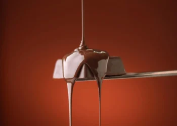 Chocolate escorrendo em fio sobre uma colher (imagem ilustrativa)