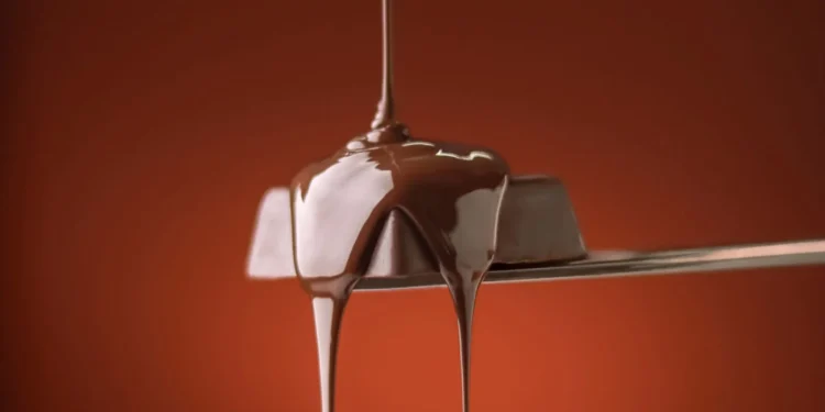 Chocolate escorrendo em fio sobre uma colher (imagem ilustrativa)