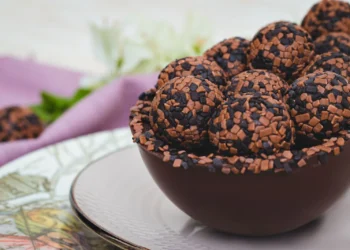 Docinhos de chocolate enrolados e cobertos com granulado, servidos em uma tigela