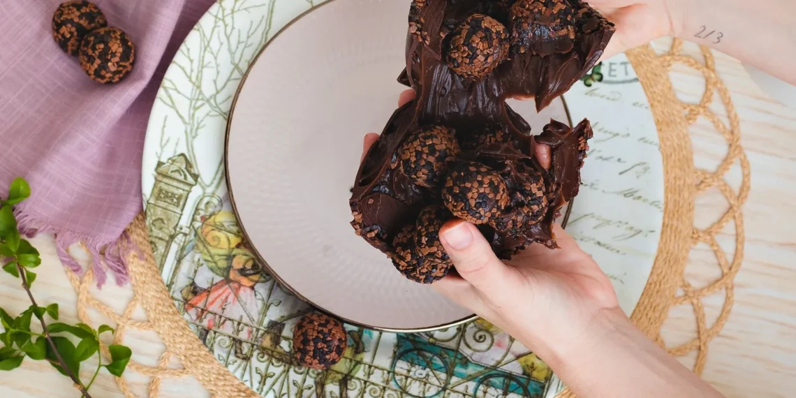 Mãos segurando docinhos de chocolate enrolados (imagem ilustrativa)