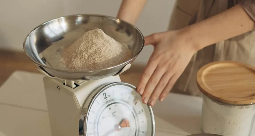 Pessoa pesando um ingrediente em uma balança de cozinha digital