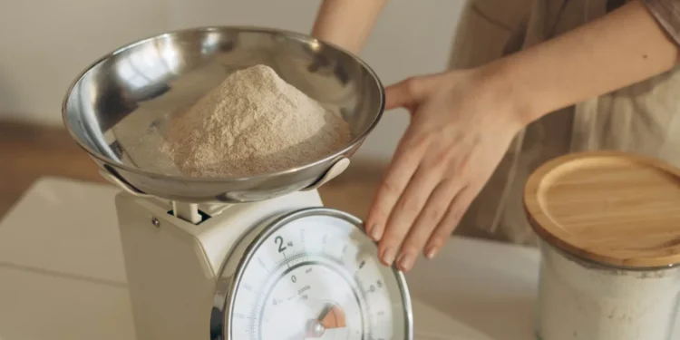 Pessoa pesando um ingrediente em uma balança de cozinha digital