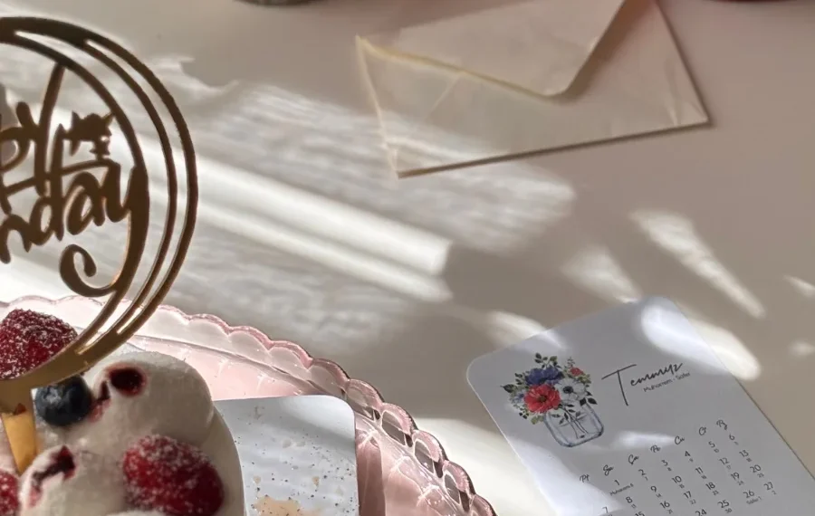 Mesa com bolo de comemoração, convite e itens de planejamento de festa