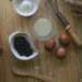 Utensílios de cozinha e ingredientes organizados sobre uma mesa de madeira, usados no preparo de doces