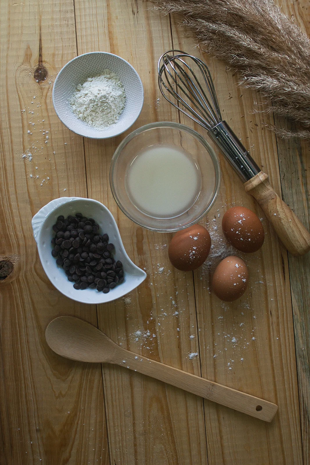 Utensílios de cozinha e ingredientes organizados sobre uma mesa de madeira, usados no preparo de doces